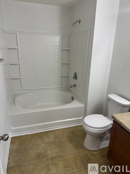 A white bathroom with a toilet, tub, and towel rack.