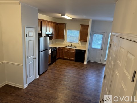 A kitchen with wooden cabinets and a stainless steel refrigerator.