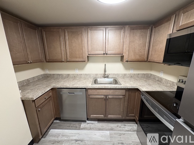 A kitchen with wooden cabinets and a granite countertop.