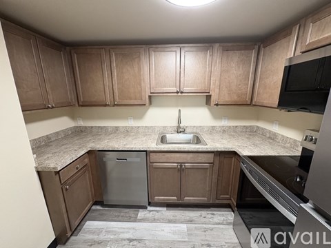 A kitchen with wooden cabinets and a granite countertop.