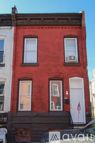A red brick building with a white door and a flag on the front.
