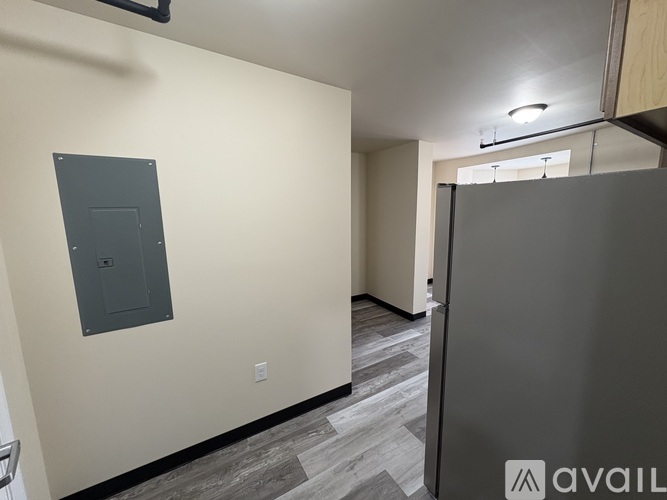 A wall with a grey electrical box mounted on it.