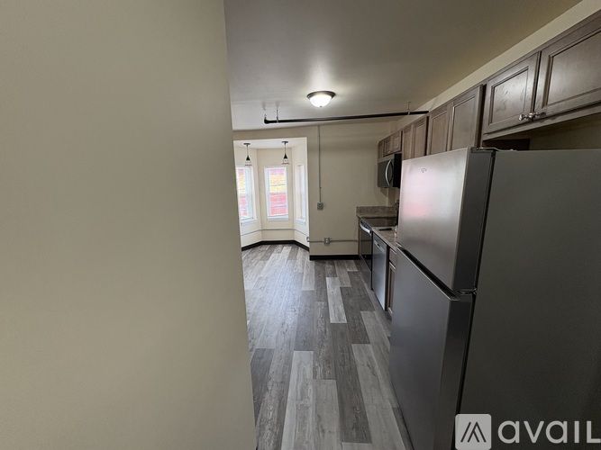 A kitchen with a refrigerator on the right side.