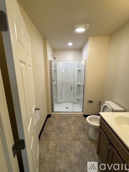 A bathroom with a toilet, sink, and shower.