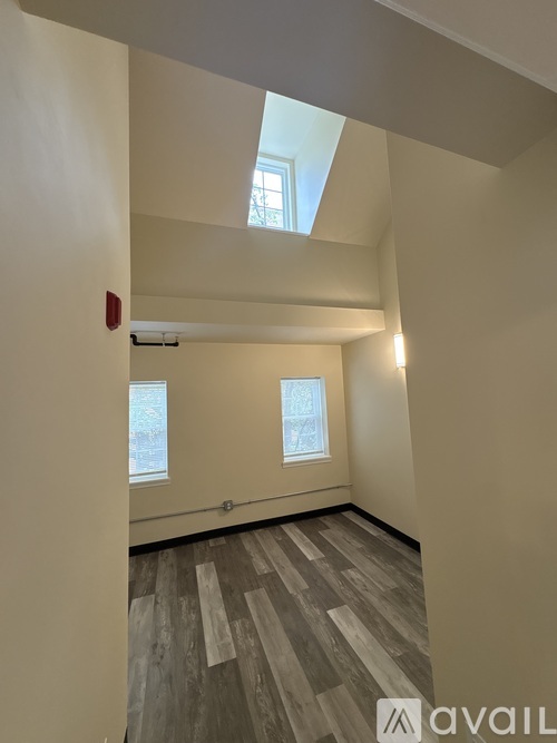 A room with wooden flooring and a skylight.