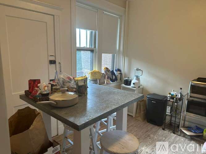 A kitchen with a table and chairs in front of a window.