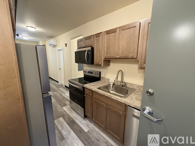 A kitchen with wooden cabinets and a refrigerator.