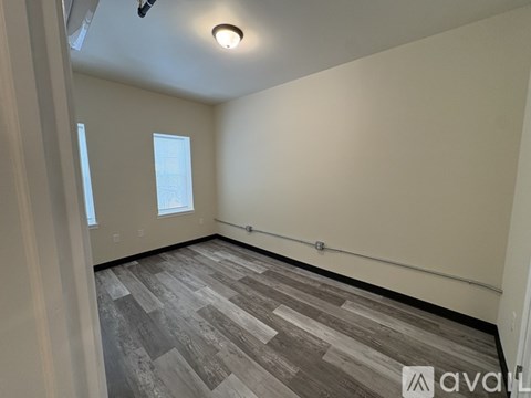 A room with wooden flooring and a window.