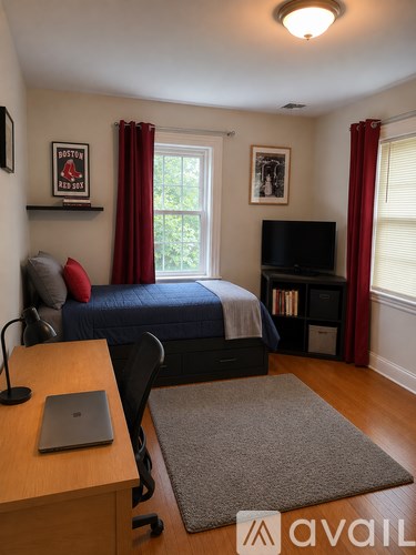 A bedroom with a bed, desk, and chair.