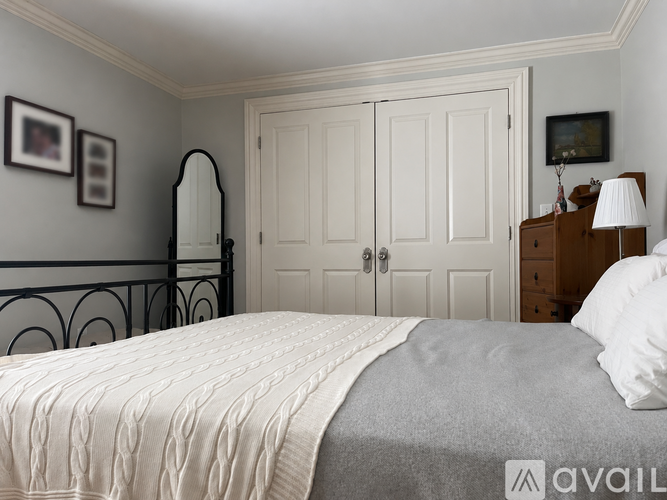 A bedroom with a bed, dresser, and mirror.