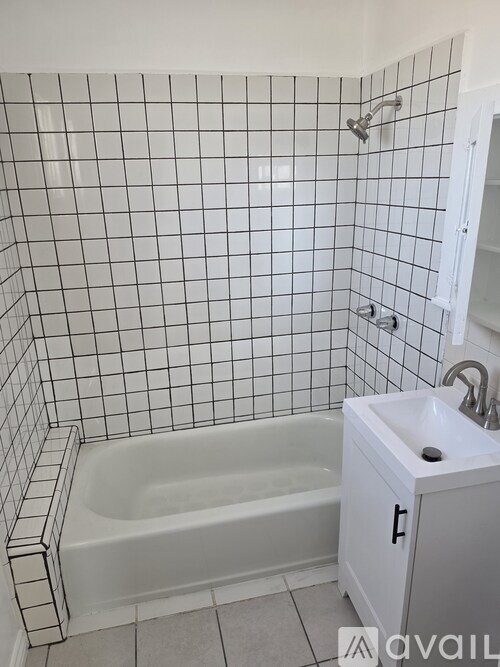 A white bathroom with a white tub and sink.