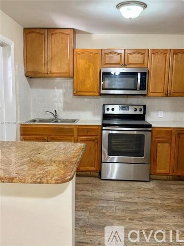 A kitchen with wooden cabinets and a granite countertop.