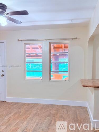 A room with a window overlooking a pool.