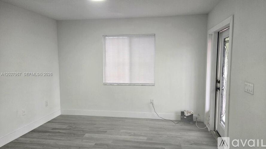 A room with a window and a door is available for rent.