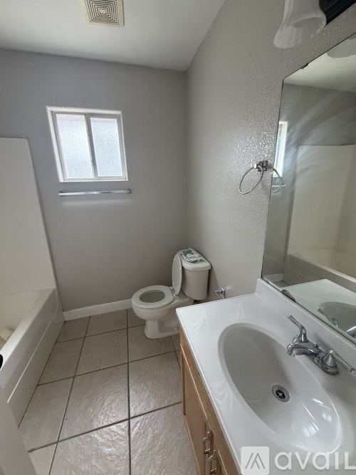 A bathroom with a toilet, sink, and mirror.
