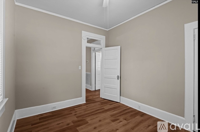 A room with a white door and a window with blinds.