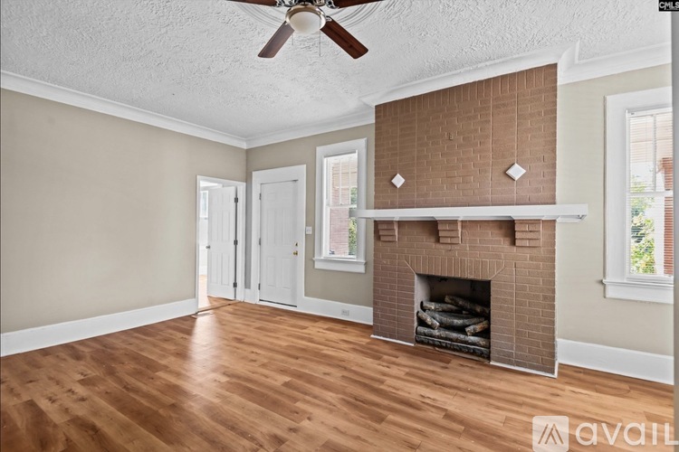 A living room with a fireplace and a ceiling fan.