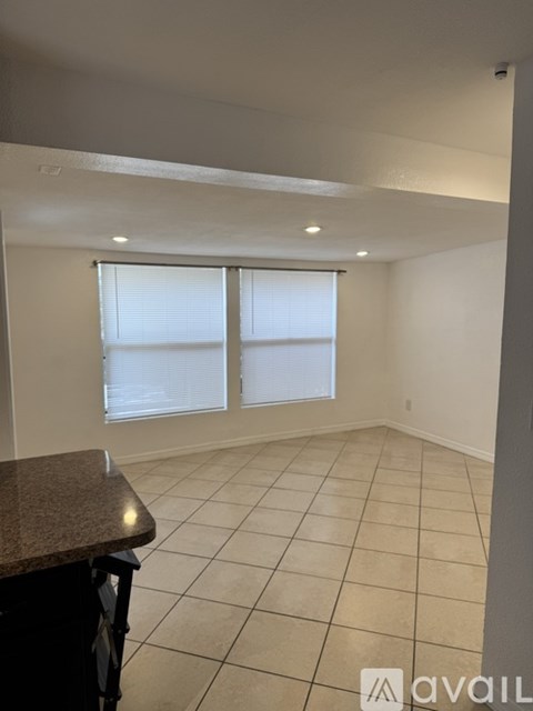 A room with a counter and a window with blinds.