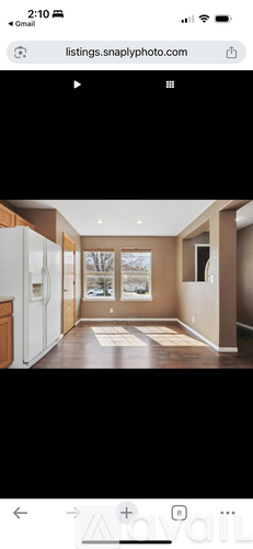 A modern kitchen with wooden cabinets and a white fridge.