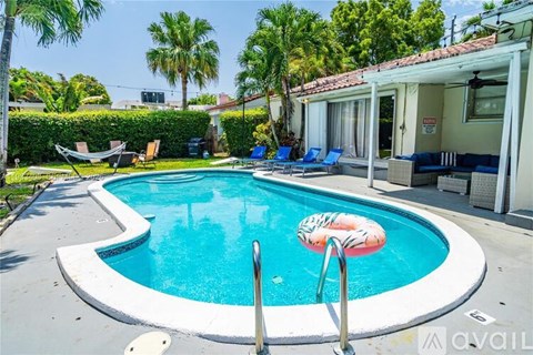 A pool with a blue water and a white poolside.