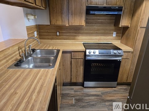 A kitchen with wooden cabinets and a stainless steel sink.