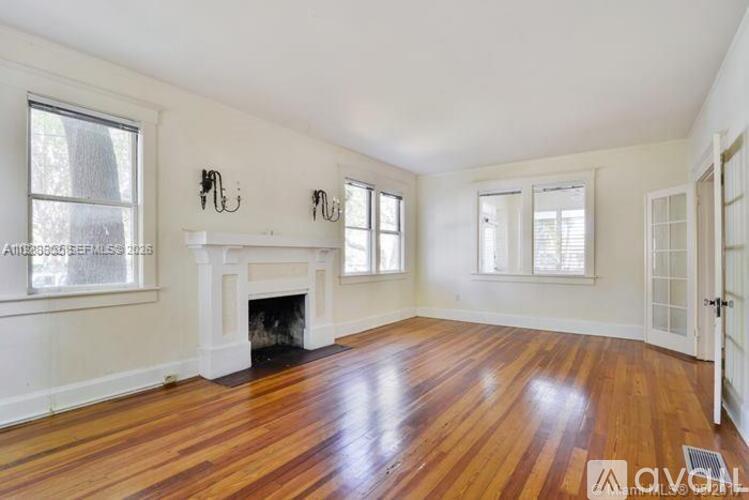 A living room with a fireplace and wood floors.