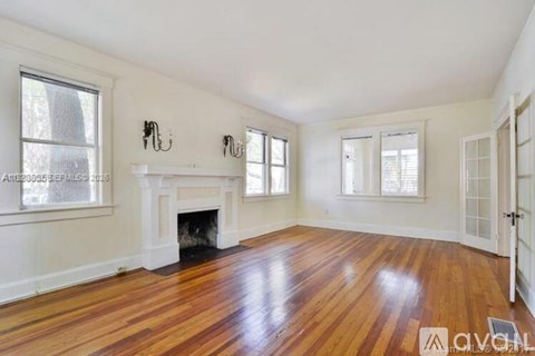 A living room with a fireplace and wood floors.