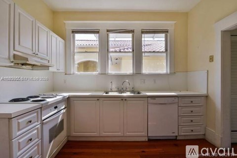 A kitchen with white cabinets and appliances.