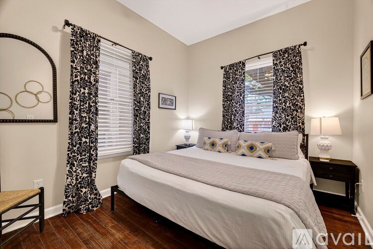 A bedroom with a large bed and a mirror on the wall.