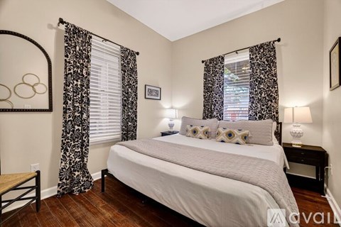 A bedroom with a large bed and a mirror on the wall.