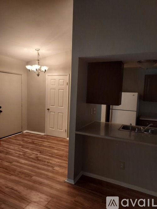 A kitchen with a wooden floor and a chandelier.