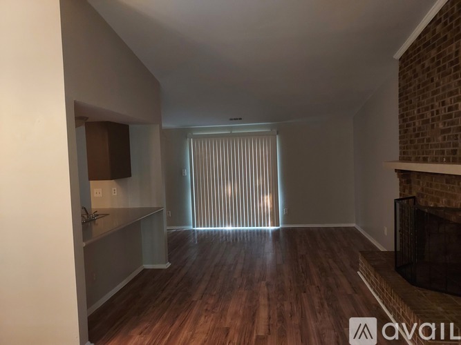 A room with wooden floors and a brick fireplace.
