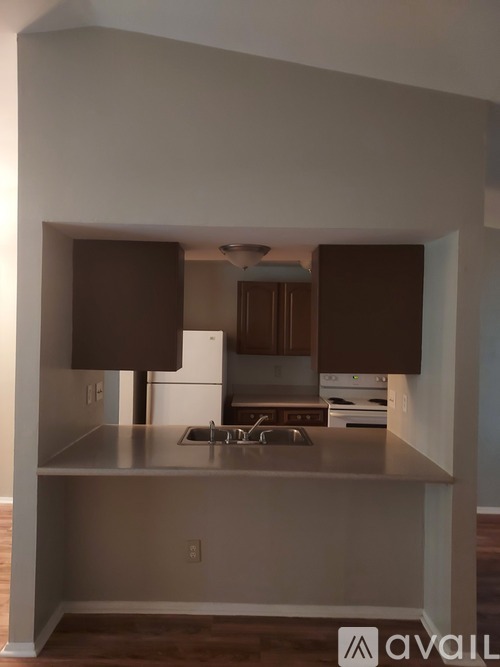A kitchen with a stainless steel countertop and wooden cabinets.