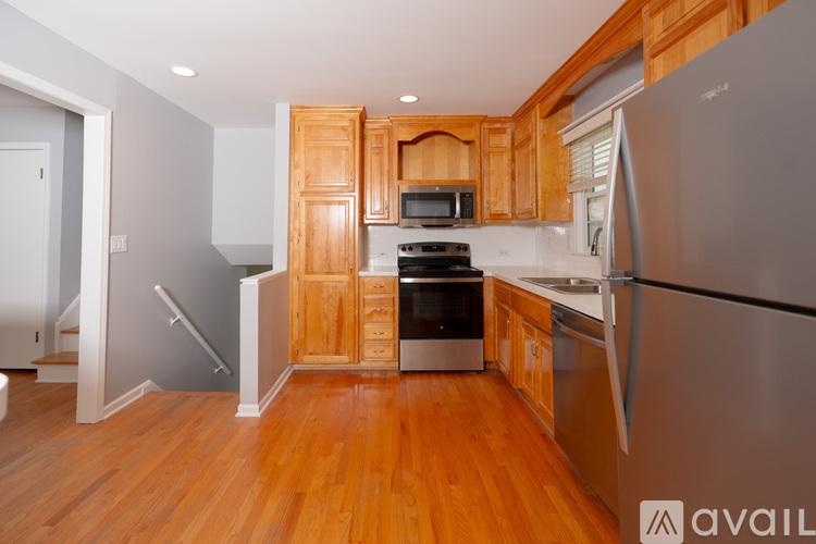 A kitchen with wooden cabinets and a stainless steel refrigerator.