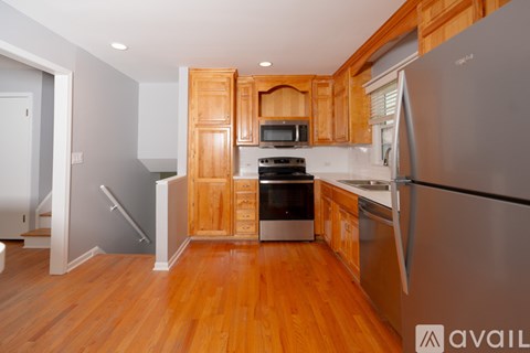 A kitchen with wooden cabinets and a stainless steel refrigerator.