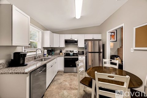 A kitchen with a table and chairs in the middle of it.