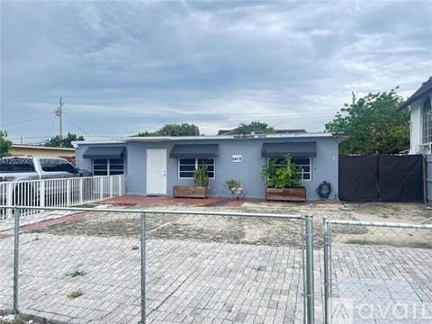 A grey building with a white fence in front.