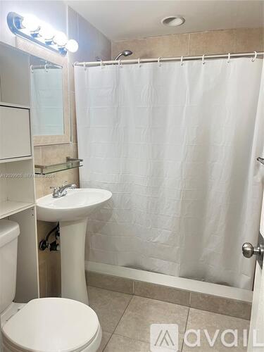 A bathroom with a toilet, sink, and shower.