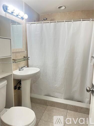 A bathroom with a toilet, sink, and shower.