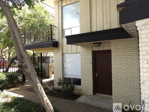 A tree is in front of a house.