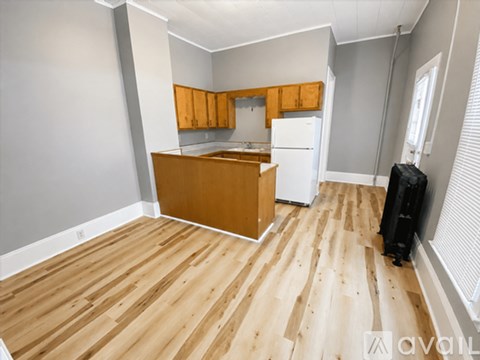 A kitchen with wooden floors and cabinets is available.