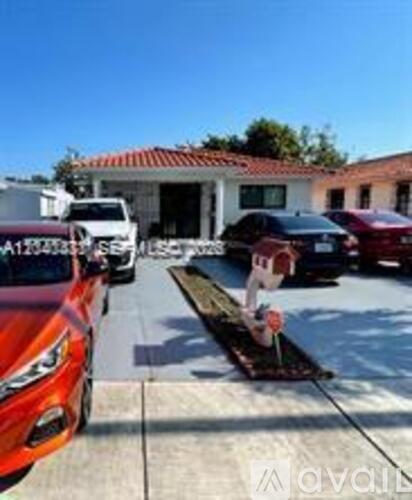 A red car is parked in front of a house.