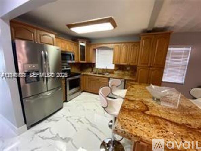 A kitchen with wooden cabinets and a granite countertop.