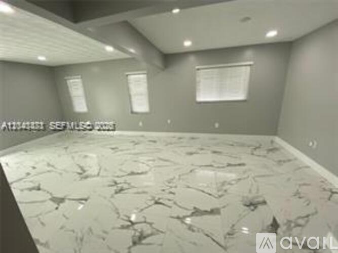 A room with a marble floor and grey walls.