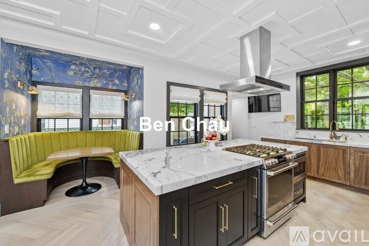 A modern kitchen with a large island and a green booth.