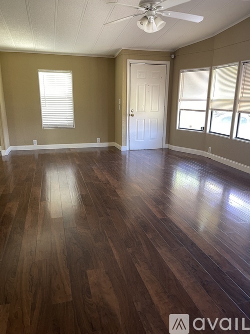 A room with wooden floors and a ceiling fan.