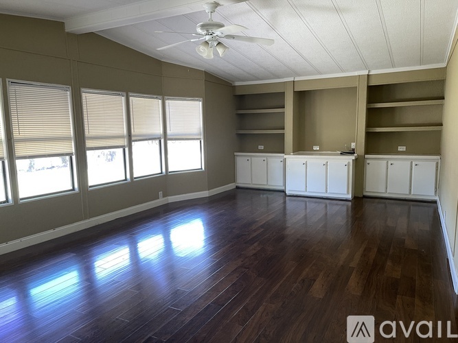 A room with wooden floors and a ceiling fan.