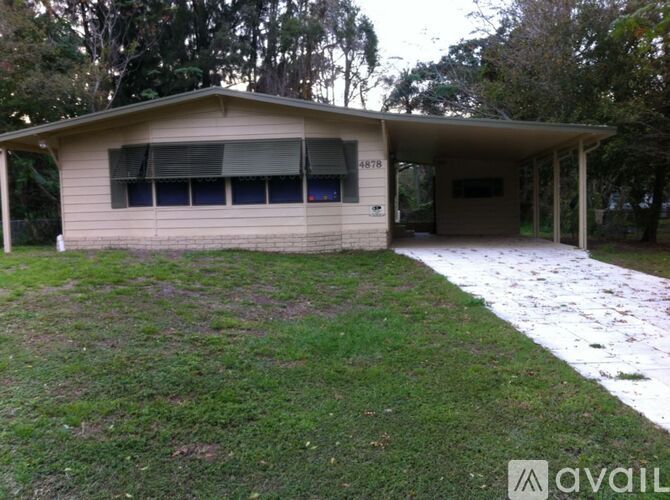 A house with the number 4878 on it is surrounded by grass and trees.