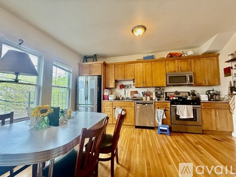 A kitchen with wooden cabinets and a dining table with chairs.