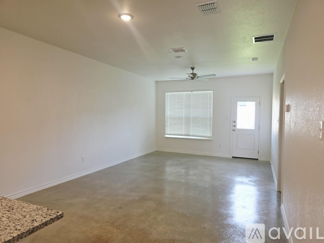A spacious room with a ceiling fan and a rug on the floor.